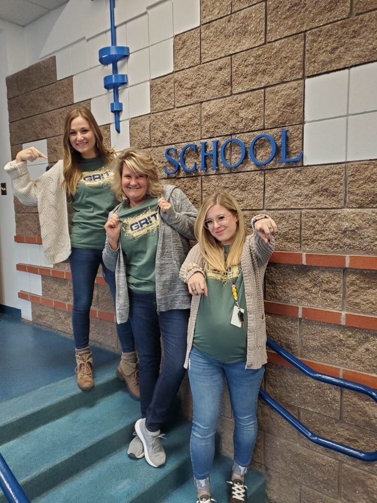 K-2 teachers standing on the stairs showing their GRIT shirts
