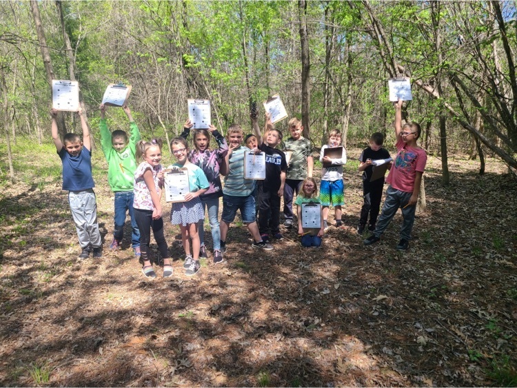 Second grade outside with their clipboards doing a nature scavenger hunt