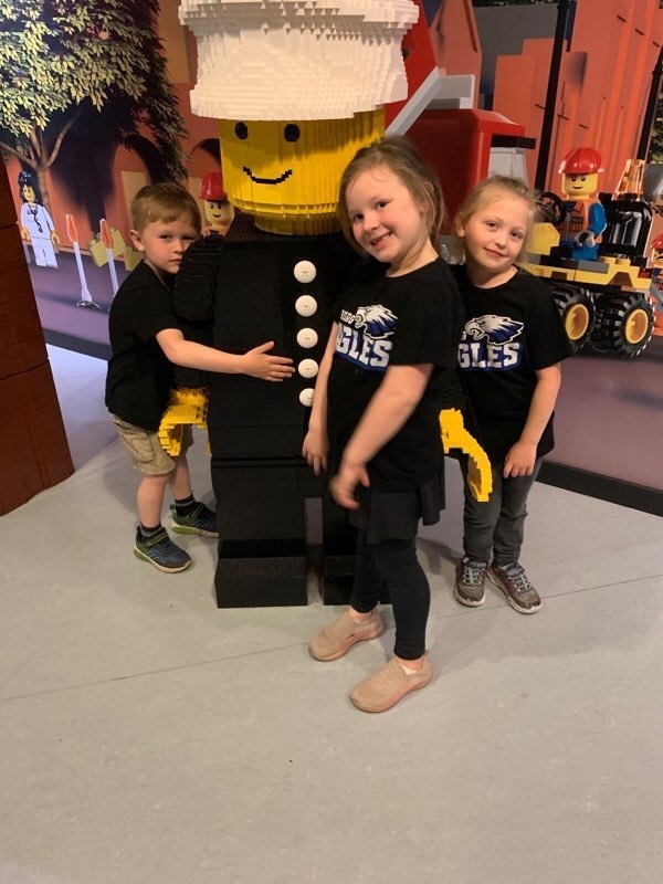 kindergarteners hugging a Lego character 